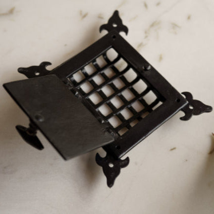 Angled view of black metal speaker grill with openable cover, featuring traditional design – retro audio hardware by Troika.