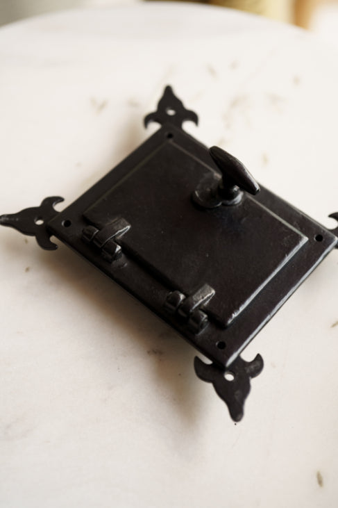 Back side of decorative cast iron speaker grill showing latch and knob mechanism – antique-inspired hardware by Troika.
