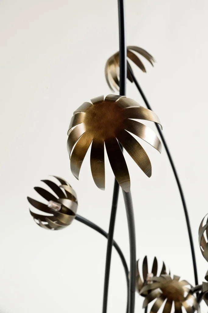 Close-up of sculptural floor lamp with bronze metal petal elements and soft golden lighting, evoking botanical elegance – artistic floor lamp from Troika.