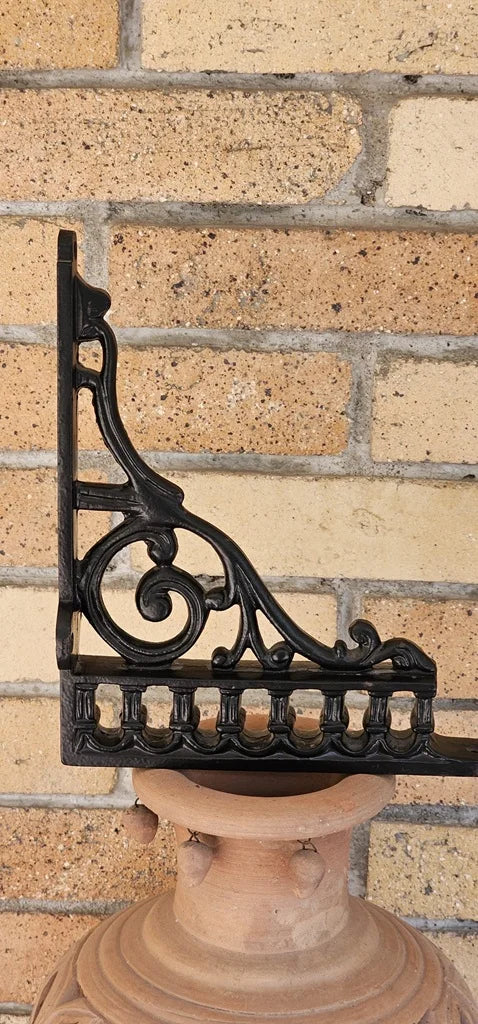Ornate black wall bracket in cast iron vintage look perfect for supporting wooden shelves.