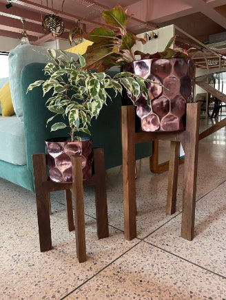 Textured copper planters with wooden stands indoor plant pots for stylish urban jungle home decor.
