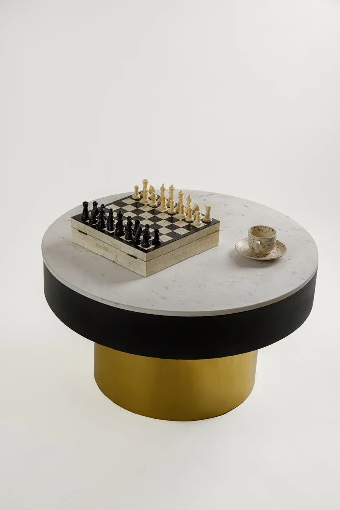 Top angle of contemporary round table with white marble surface and gold base.