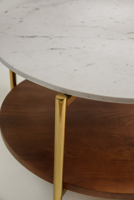 Close-up of marble and wood round coffee table with golden structure.
