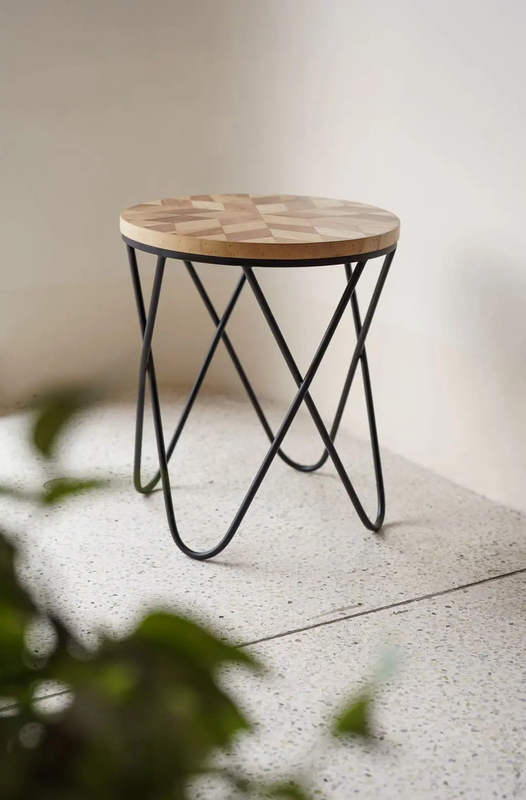 Stylish round coffee side table with wooden geometric top and black metal frame base – modern handcrafted furniture by Troika.