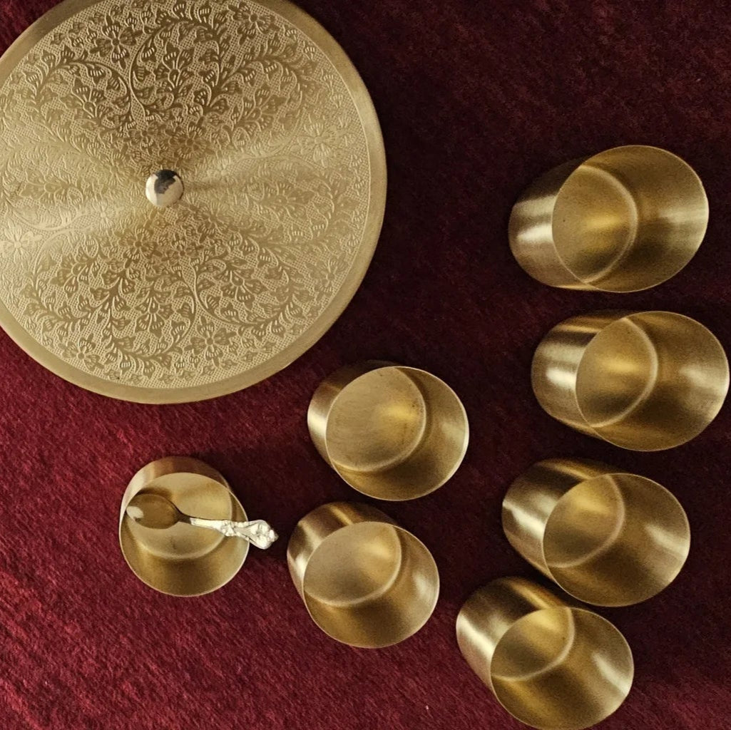 Overhead view of traditional brass spice box set includes engraved lid and serving spoon.