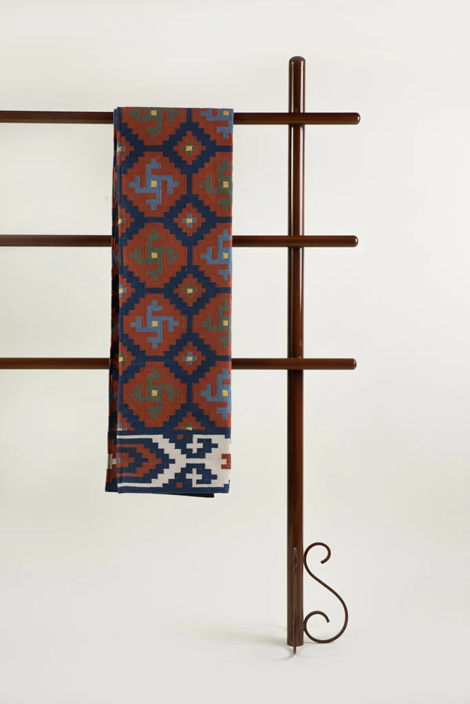 Terracotta tales handwoven dhurrie on display bold tribal pattern with rich earthy tones.