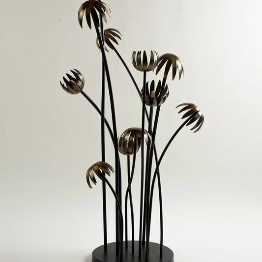 Contemporary floral floor lamp sculpture with metallic petal shades on tall black stems, ideal for eclectic or modern interior spaces – designer lighting by Troika.