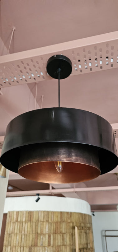 Minimalist black and copper pendant lamp hanging from ceiling – contemporary lighting for kitchens and cafés.