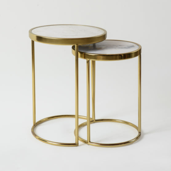 Minimal nesting tables with white marble tops and gold metal legs.