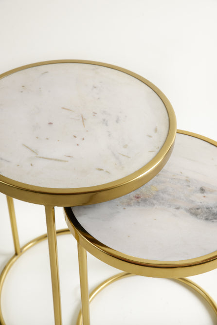 Side view of stacked marble nesting tables with elegant gold finish.