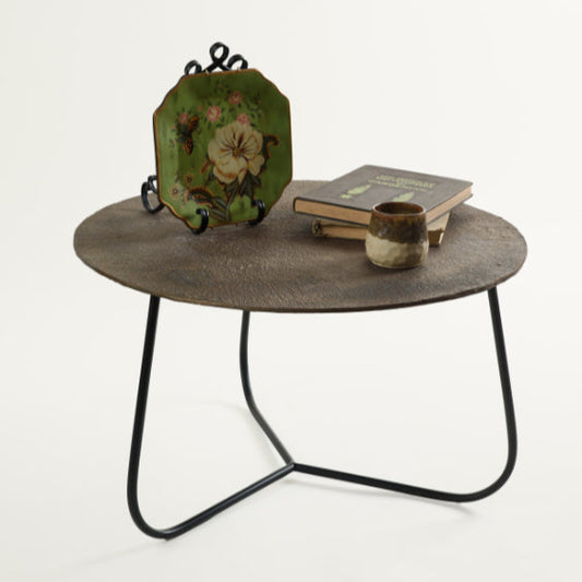 Rustic metal coffee table styled with green floral plate, stacked books, and a ceramic cup – curated Troika Life living room decor.