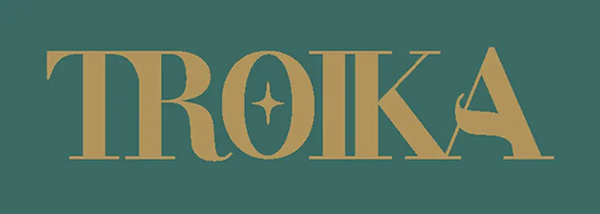 Troika logo in golden serif lettering with centered star accent, placed on dark teal backdrop.