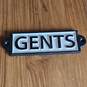 Cast iron wall sign reading 'GENTS'. Black and white, ideal for restroom labeling in commercial or retro spaces.