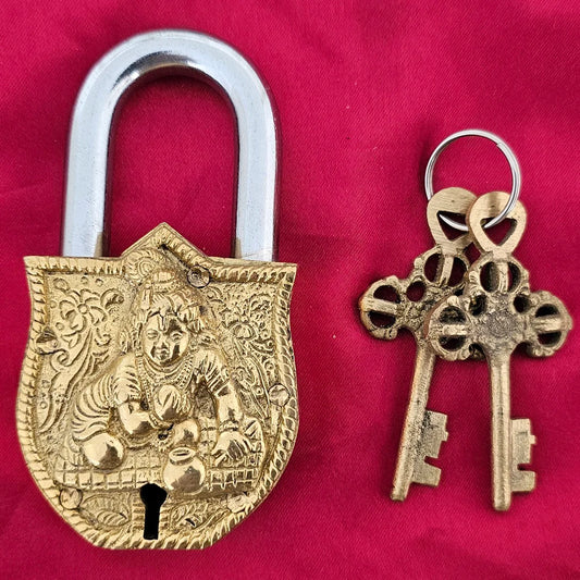 Antique brass padlock featuring Lord Krishna carving – handcrafted Indian lock with ornate detailing and vintage keys.
