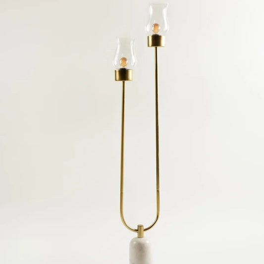 Sleek brass twin-light floor lamp with marble base minimalist style for luxury interiors.